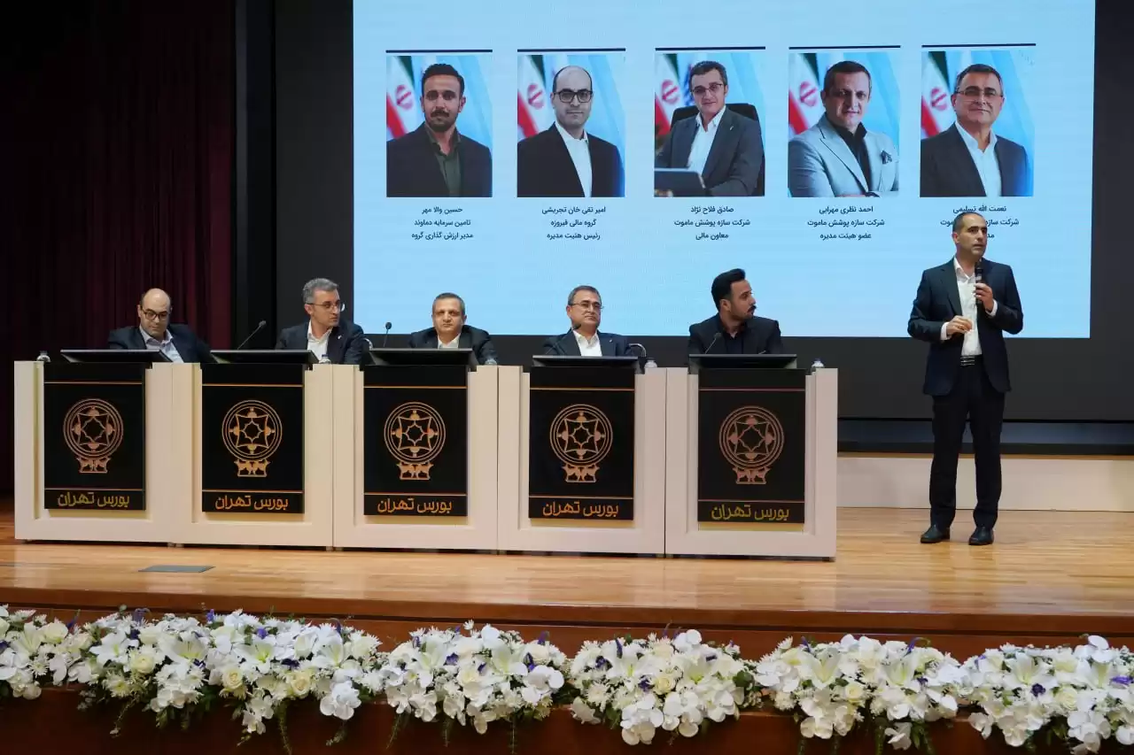 A person standing in front of a podium with a group of people

Description automatically generated